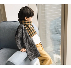 Detail of yellow and black checkered scarf paired with grey knitted cardigan for children