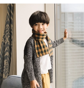 Detail of yellow and black checkered knitted scarf for children with fluffy texture