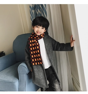 Detail of child wearing a thick plaid scarf with a grey wool coat for winter warmth