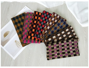 Macro detail of multicolored checkered knit scarves in multiple color options and patterns