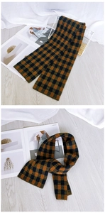 Detailed view of brown and black plaid check pattern on soft knitted winter scarf
