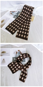 Detail of checkered knit scarf in brown and beige colors for autumn winter warmth