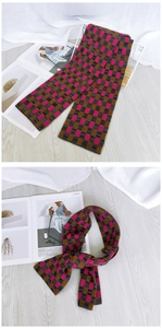 Detail of pink and brown checkered knit scarf showcasing soft texture and stylish knot