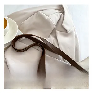 Detail of premium off-white canvas tote with reinforced dark brown leather handles