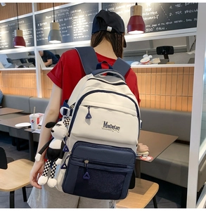Sac à dos décontracté en toile blanche avec panneaux contrastés bleus dans un café
