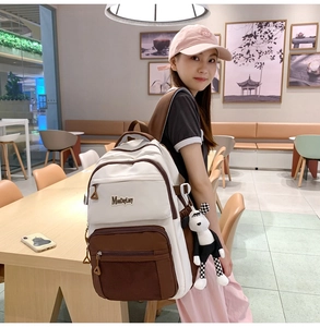 Détail d'un sac à dos décontracté avec pendentif chien porté par un mannequin en café