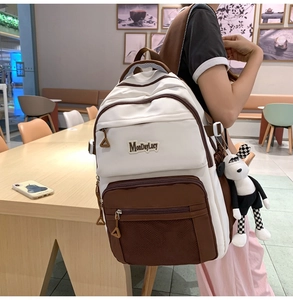 Détail d'un sac à dos en toile à plusieurs poches avec breloque de chien en peluche