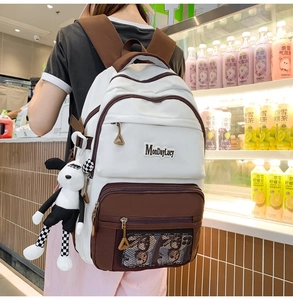 Détail d'un sac à dos multicolore à poches multiples avec étiquette MonDayLucy et breloque