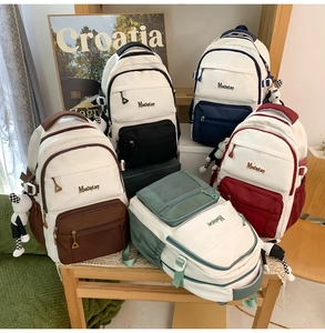 Vue détaillée de sacs à dos en toile colorés avec des pendentifs mouton à damier