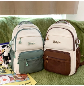 Détail de sacs à dos en nylon bicolores avec poches en filet et porte-clés chien en peluche