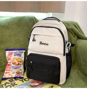Détail d'un sac à dos bicolore avec panneaux noir et blanc et poche avant en filet