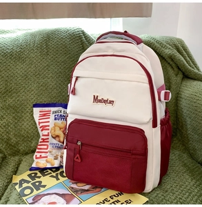 Détail du rangement multicouche sur un sac à dos beige et bordeaux avec poche en filet