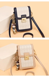 Detail of quilted texture and bull pendant on contrast color crossbody phone bag