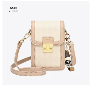 Detail of khaki quilted mobile phone bag with golden push lock and cute cow pendant