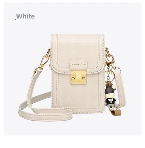 Close-up of cream quilted phone bag with gold clasp and cartoon calf pendant detail