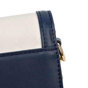 Quilted crossbody bag with blue leather trim and golden metal ring detail