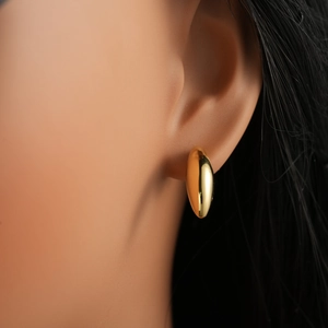 Close-up of model wearing polished 18K gold teardrop earrings for a minimalist look