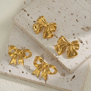 Elegant 18k gold plated stainless steel bow earrings on minimalist travertine stone
