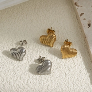 Textured 18K gold and silver heart stud earrings with horizontal ribbed metal finish