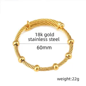 Dettaglio macro del bracciale estensibile in acciaio dorato 18k con perline lisce lucide