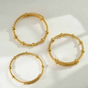 Vista macro dettagliata di bracciali a cavo in acciaio inossidabile placcato oro 18k