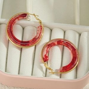 Gold-plated chunky hoop earrings with marble red resin in a pink velvet jewelry box