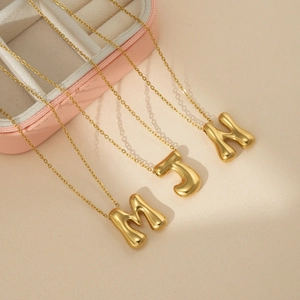 Colliers dorés avec pendentifs lettres M, J, H effet ballon 3D sur boîte à bijoux