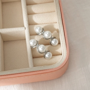 Detailed macro view of triple pearl earrings showcased in a premium jewelry gift box
