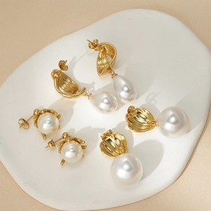 Three-piece set of elegant 18k gold pearl earrings featuring shell and arc shapes