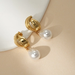 Detailed close-up of 18k gold-plated interwoven metal earrings with water-drop pearls