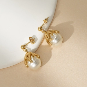 Detailed macro view of baroque pearl earrings with golden minimalist artistic settings