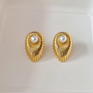 Detailed view of vintage gold shell earrings with central pearl and ribbed texture