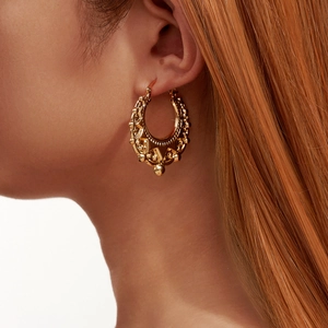 Golden boho hollow geometric hoop earring with intricate dot patterns on a side-profile model