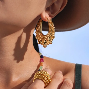 Retro geometric hollow gold earrings with bohemian ethnic texture on female model