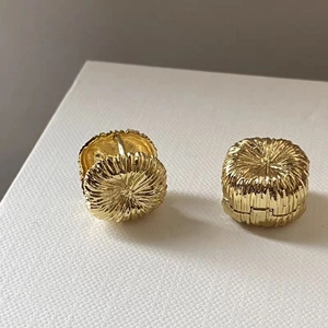 Vintage gold plated earrings with textured fireworks pattern and secure hoop design