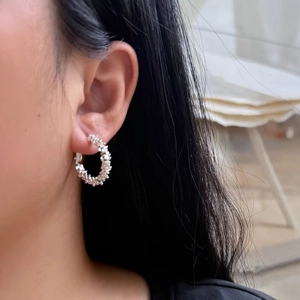 French style C-shaped silver earrings with textured crushed silver finish worn by a model