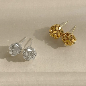 Detailed view of spherical stud earrings with metallic sequins in gold and silver finish