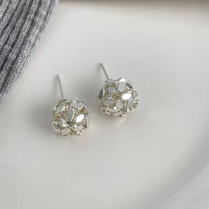 Silver sequin woven spherical stud earrings with textured metallic finish on white background