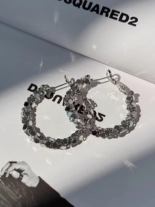 Detailed macro view of silver hoop earrings with shimmering geometric metallic sequins