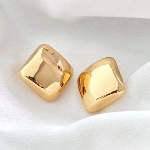 Boucles d'oreilles carrées minimalistes en or 18 carats sur tissu de soie blanc