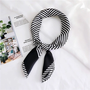 Detail of black and white striped satin scarf with silky texture and knotted styling