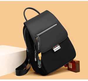 Détail du sac à dos en nylon noir imperméable avec fermeture éclair et plaque métallique