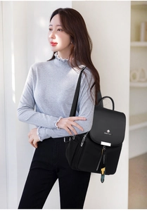 Détail d'un sac à dos noir en nylon avec boucle en métal et pendentif Urban Trend