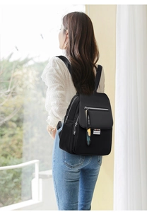 Vue arrière d'un mannequin portant un sac à dos en nylon noir étanche avec plaque mode