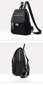 Détail du sac à dos noir en nylon imperméable avec logos en métal et languettes décoratives