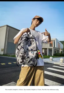 Close-up of backpack with cartoon prints and a green dinosaur plush keychain detail