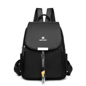 Sac à dos noir en nylon imperméable pour femme avec finitions en cuir et pendentif décoratif