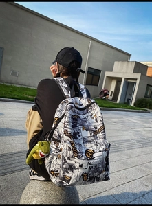 Outdoor shot showing detail of the urban street style backpack with manga print and dinosaur charm