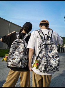 Detailed view of urban graffiti backpack with plush dinosaur charm on a model's back