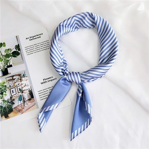 Detailed close-up of a blue and white striped silk scarf tied in an elegant knot